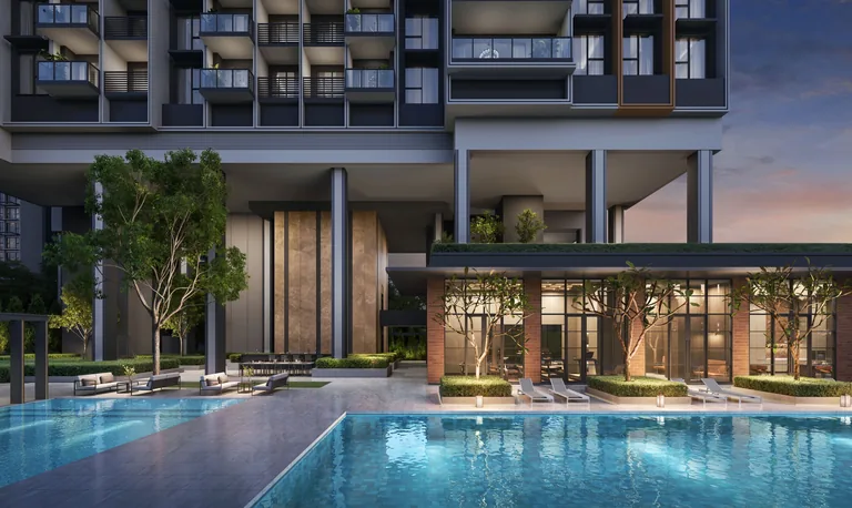 Hudson Place Residences, artist&rsquo;s impression: the pool at dusk beneath the raised tower, with the lit glass and brick of the clubhouse and loungers along the deck